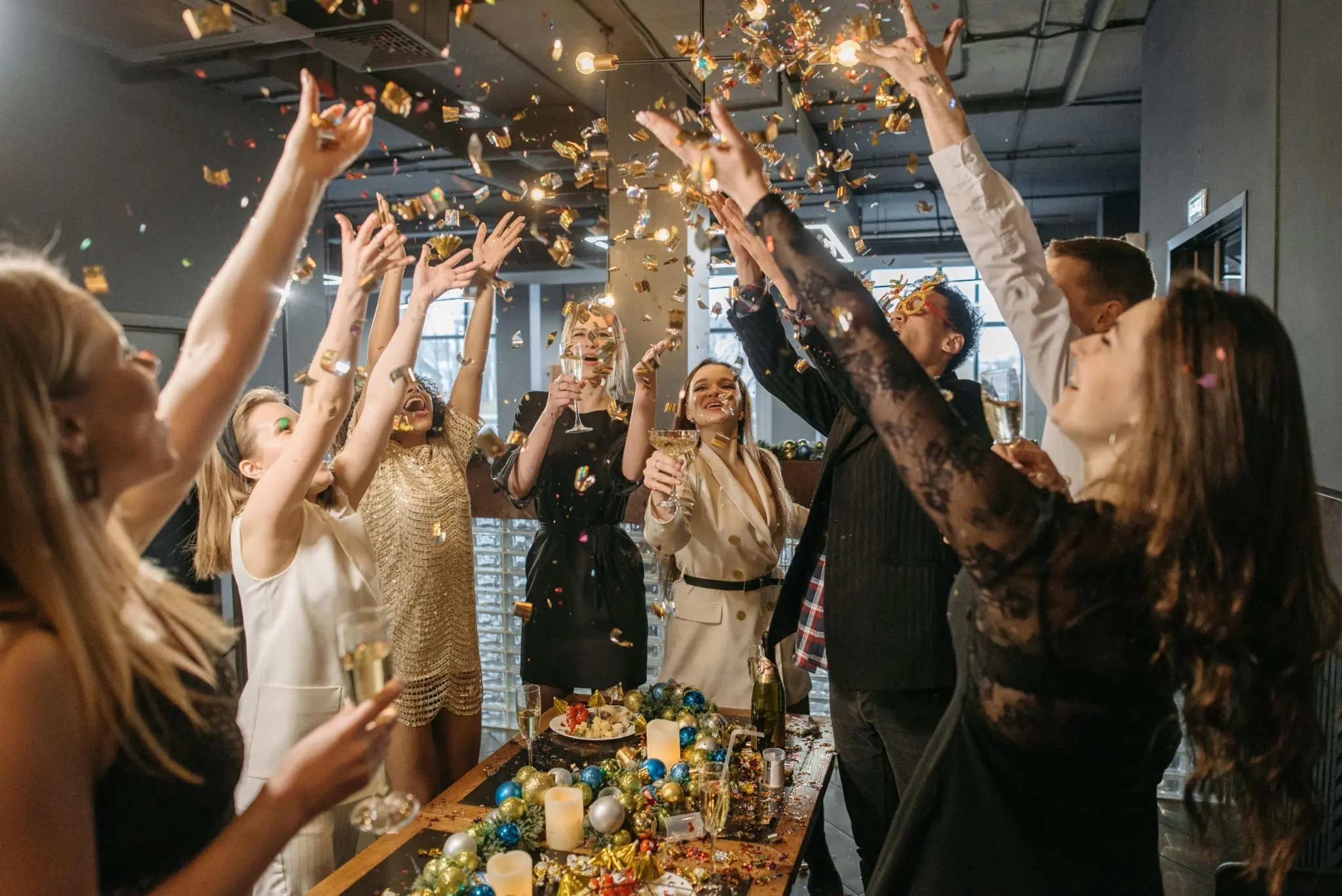 Coworkers celebrating a work anniversary with confetti, champagne, and festive decorations